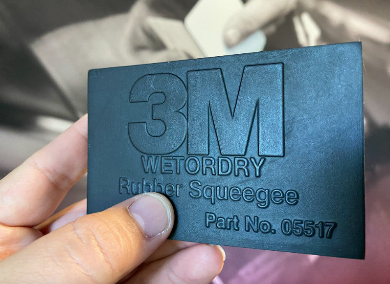 3M Wet or Dry Squeegee held in hand, demonstrating its flexibility and ease of use for paint protection.