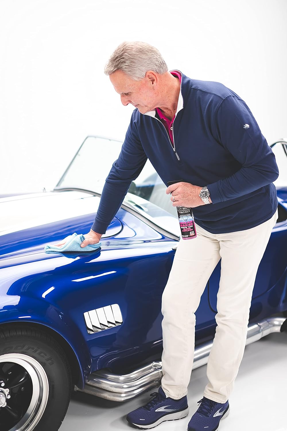 Professional detailer enhancing a car's gloss finish with P&S Dream Maker at an auto detailing shop.